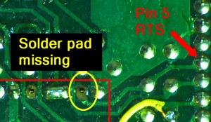 The source of the trouble: the damaged/missing solder pad and portion of the trace leaving pin 6 of IC1, eventually routing to pin 5 of the RS232 connector. My bad.