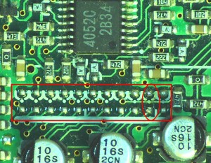 This is the bank of solder pads which is used at the factory for installing configuration jumpers. The position indicated with an ellipse is I removed the Transmit Range jumper from, seen after it was removed.